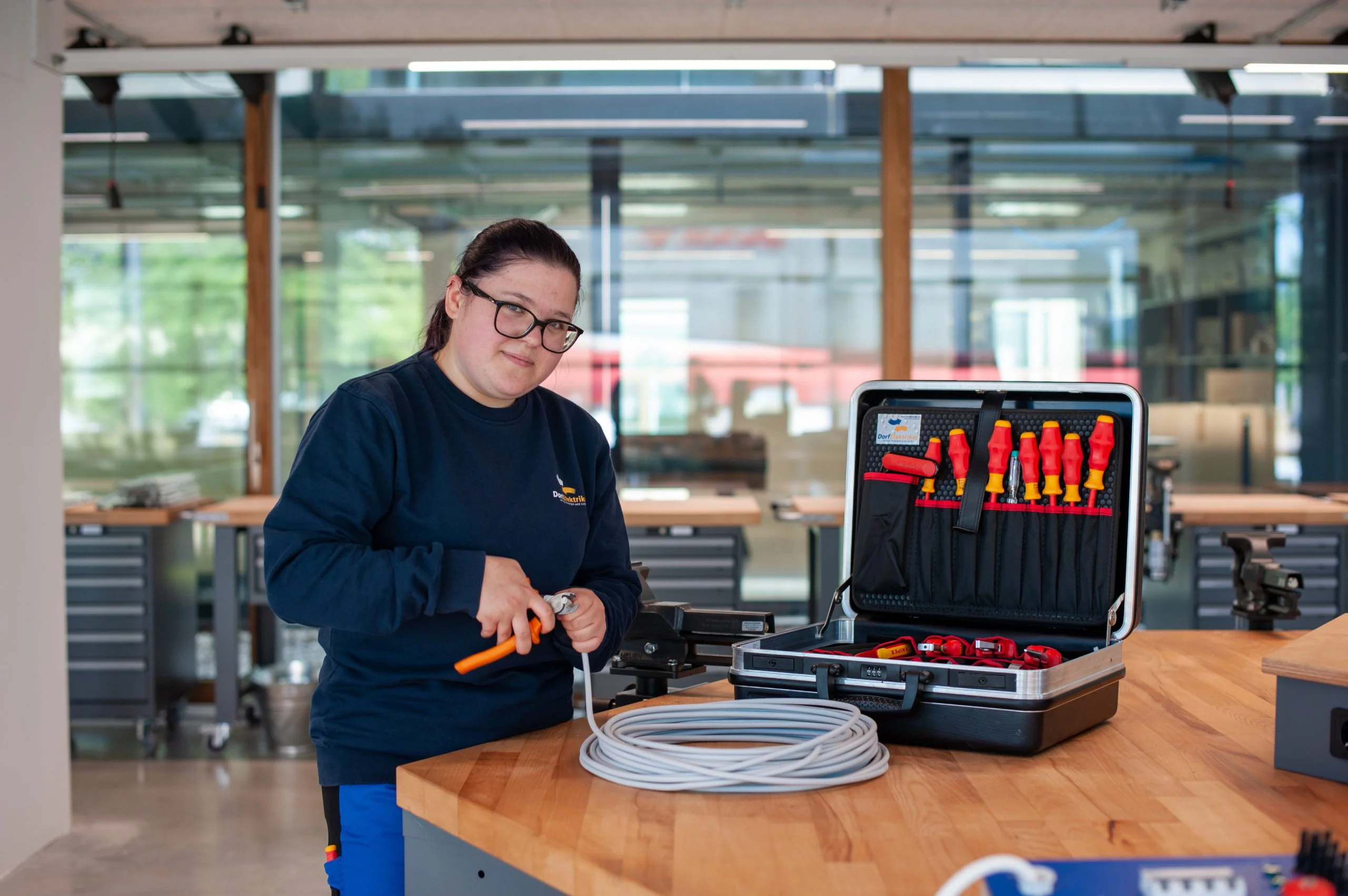 Lehrling mit Werkzeugkoffer, Jeanine Lang vom Dorfelektriker in der Lernwerkstatt